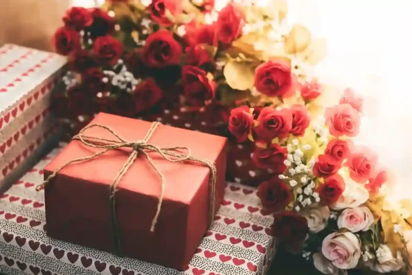 Gift delivery Qatar with wrapped gift box and red rose bouquet for special occasions